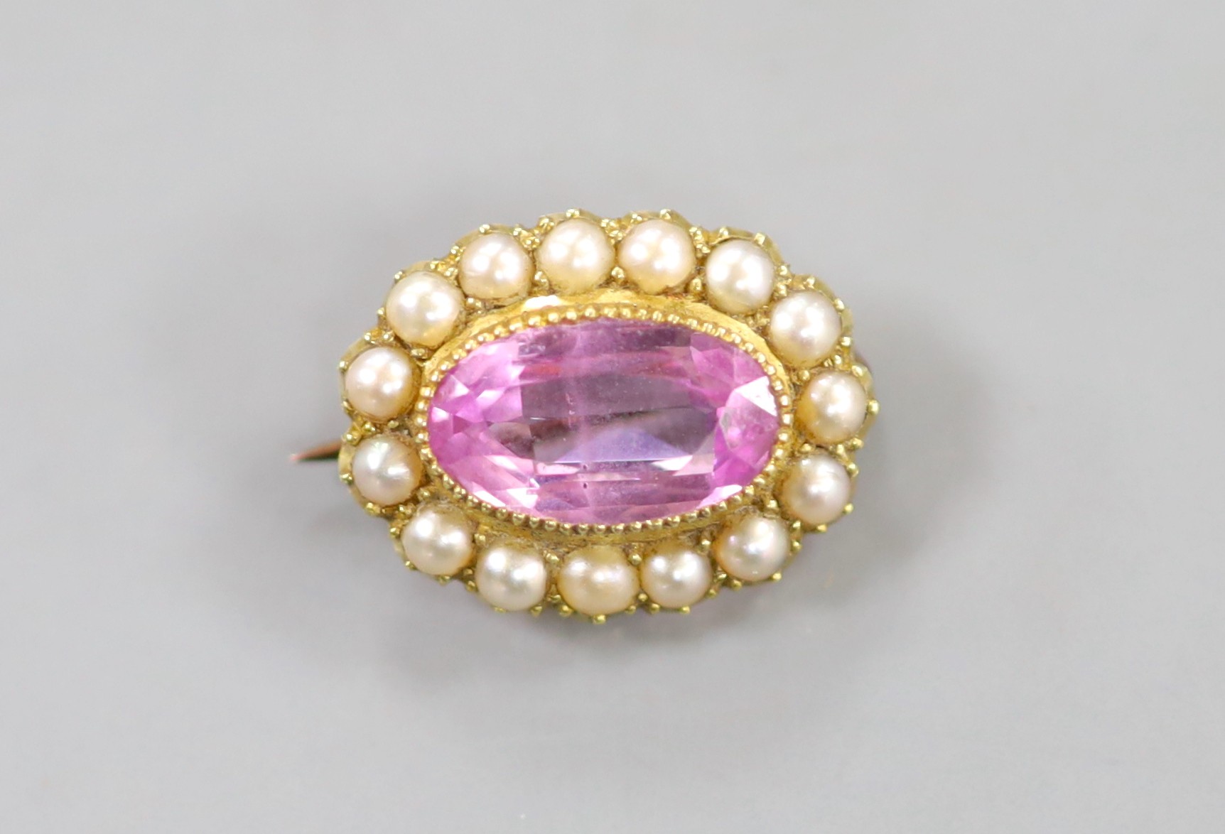 A yellow metal synthetic? pink sapphire and split pearl set oval brooch, 17mm, gross weight 2.4 grams.